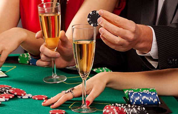 Gamblers holding casino chips and glasses of champagne